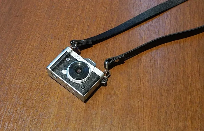 木製のテーブルに置かれたミニレトロカメラ