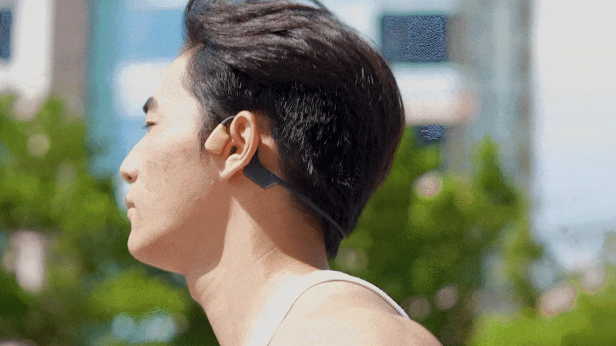 骨伝導イヤホンを装着してランニングする男性