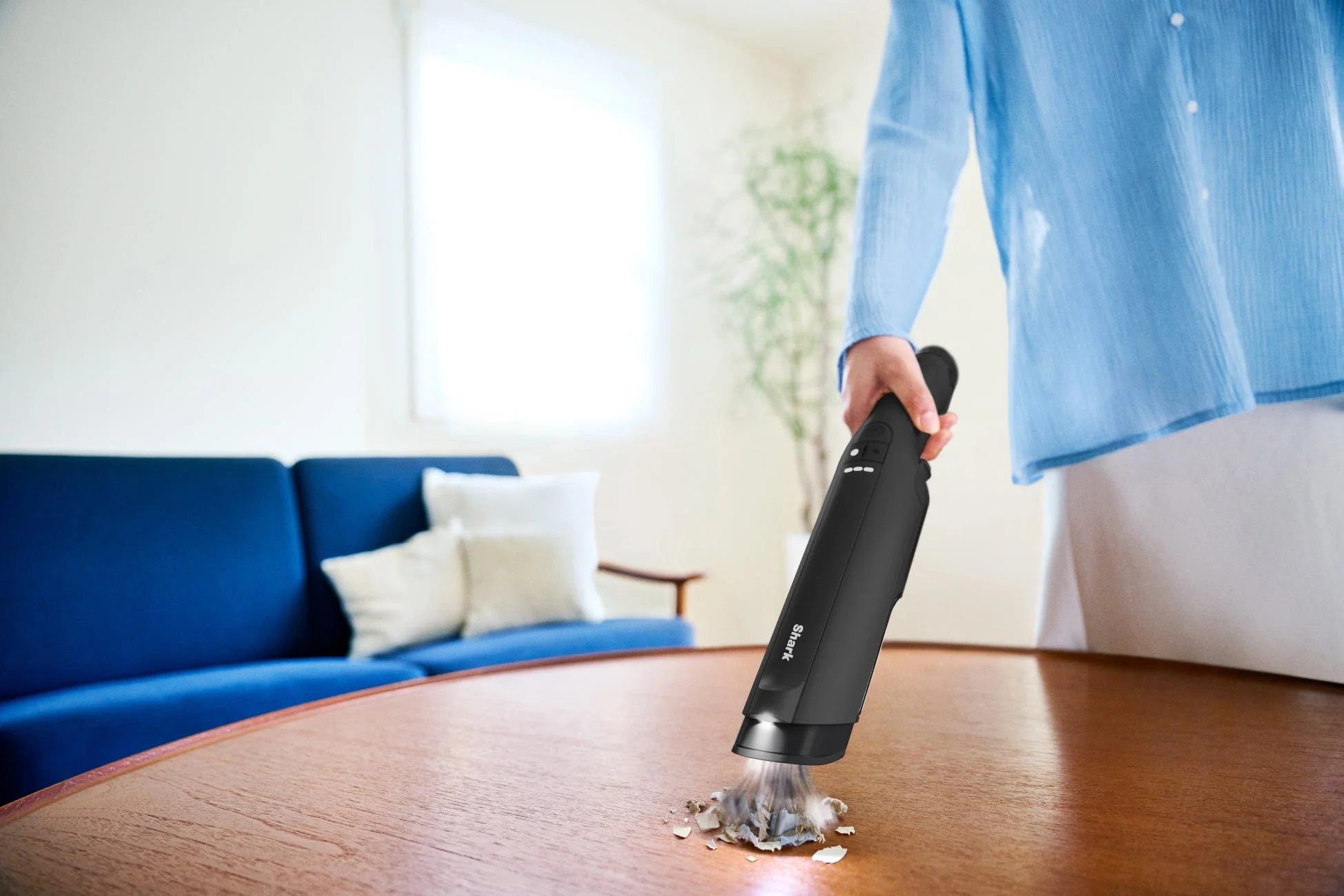 ハンディクリーナーでテーブルのゴミを掃除する様子