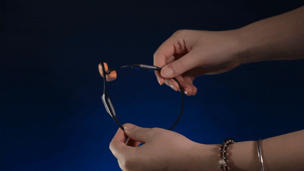 柔軟性のあるネックバンド型ヘッドホンを曲げる手