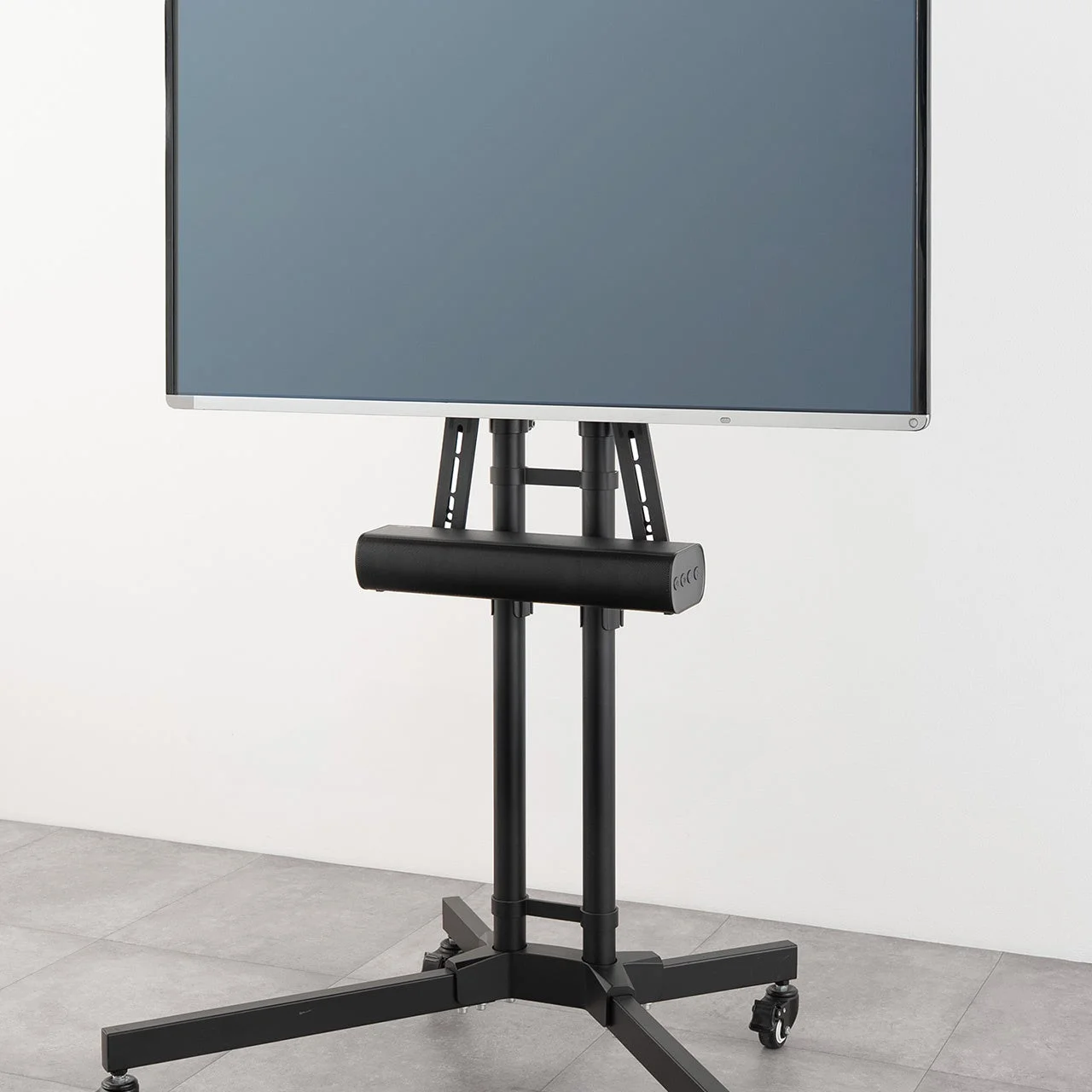 黒いキャスター付きテレビスタンドに大型ディスプレイが設置された画像