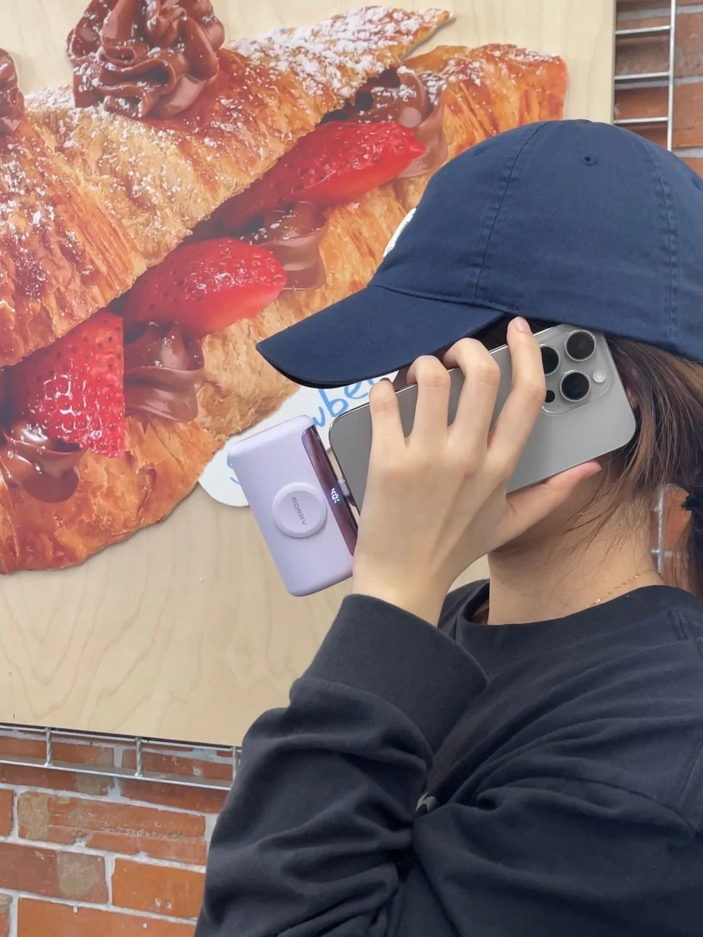 人物がスマートフォンを顔に当てている様子