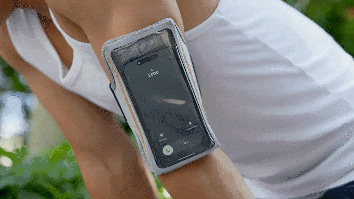 ランニング中にスマートフォンをアームバンドに装着した人物