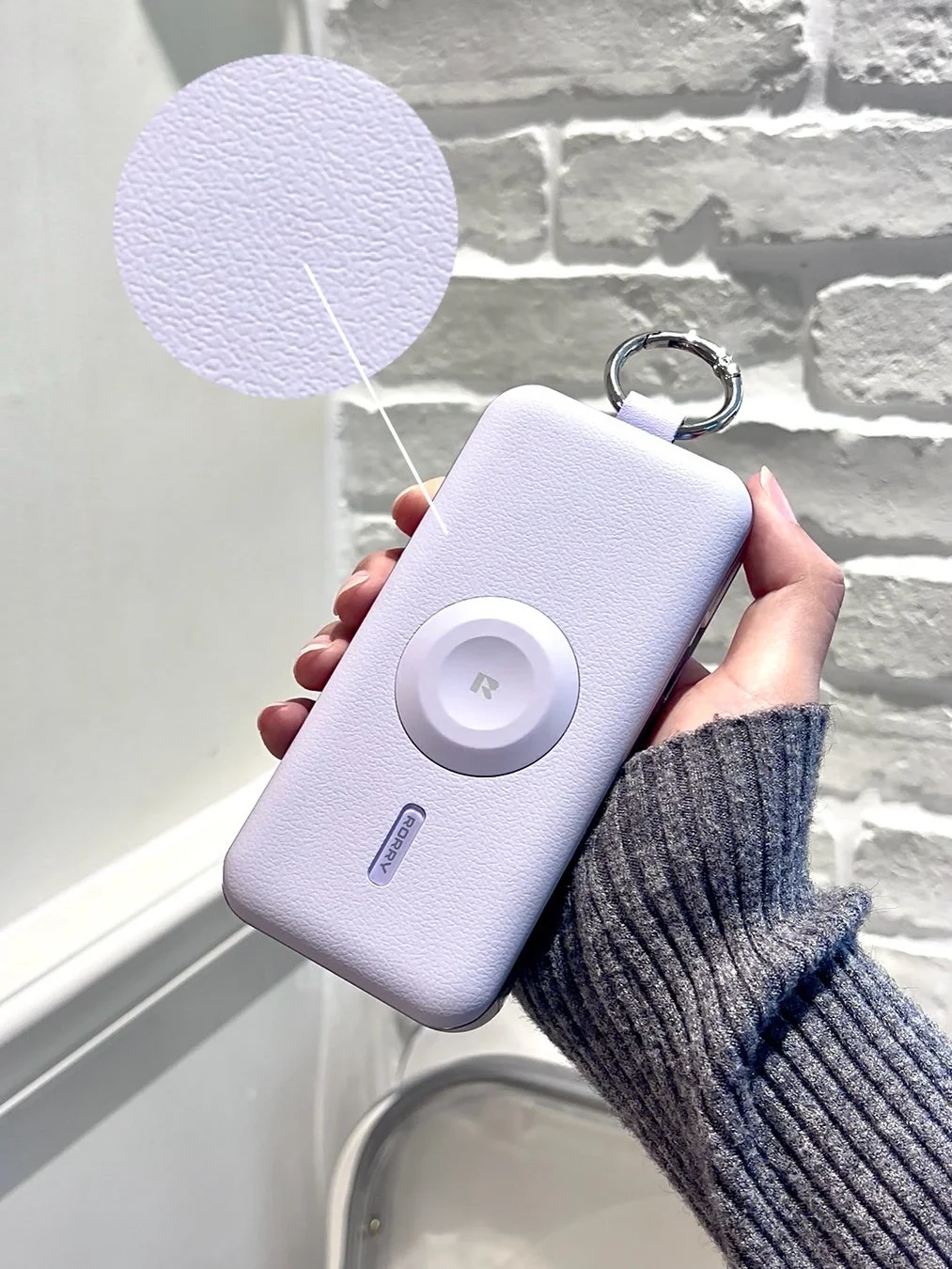 手に持ったラベンダー色のモバイルバッテリー