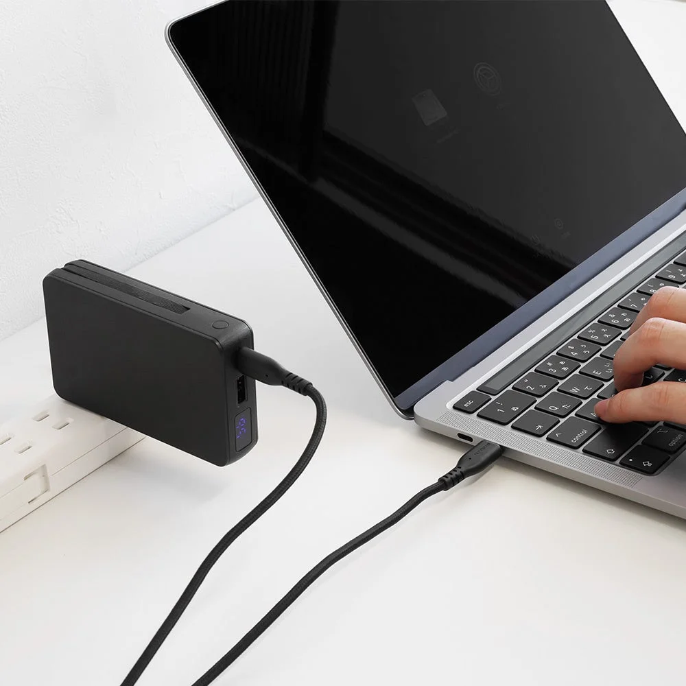 モバイルバッテリーがノートパソコンに接続され充電している様子