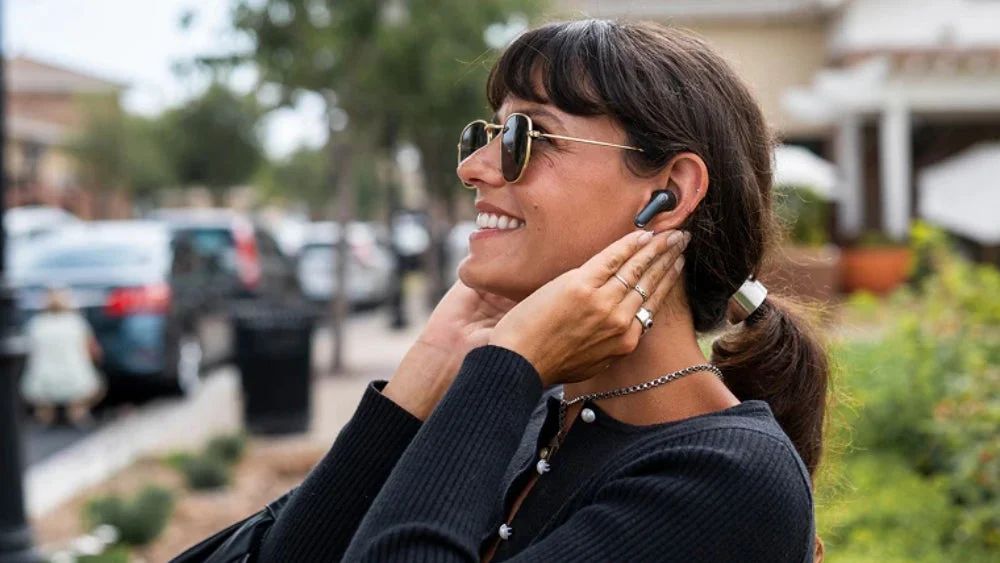 イヤホンを装着して笑顔の女性