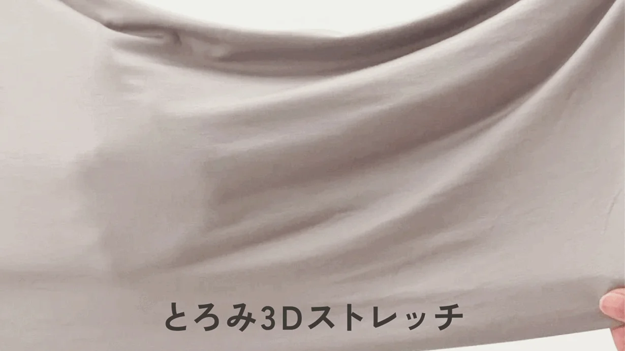 とろみのあるベージュ色の布地が伸びている様子を捉えた画像です。