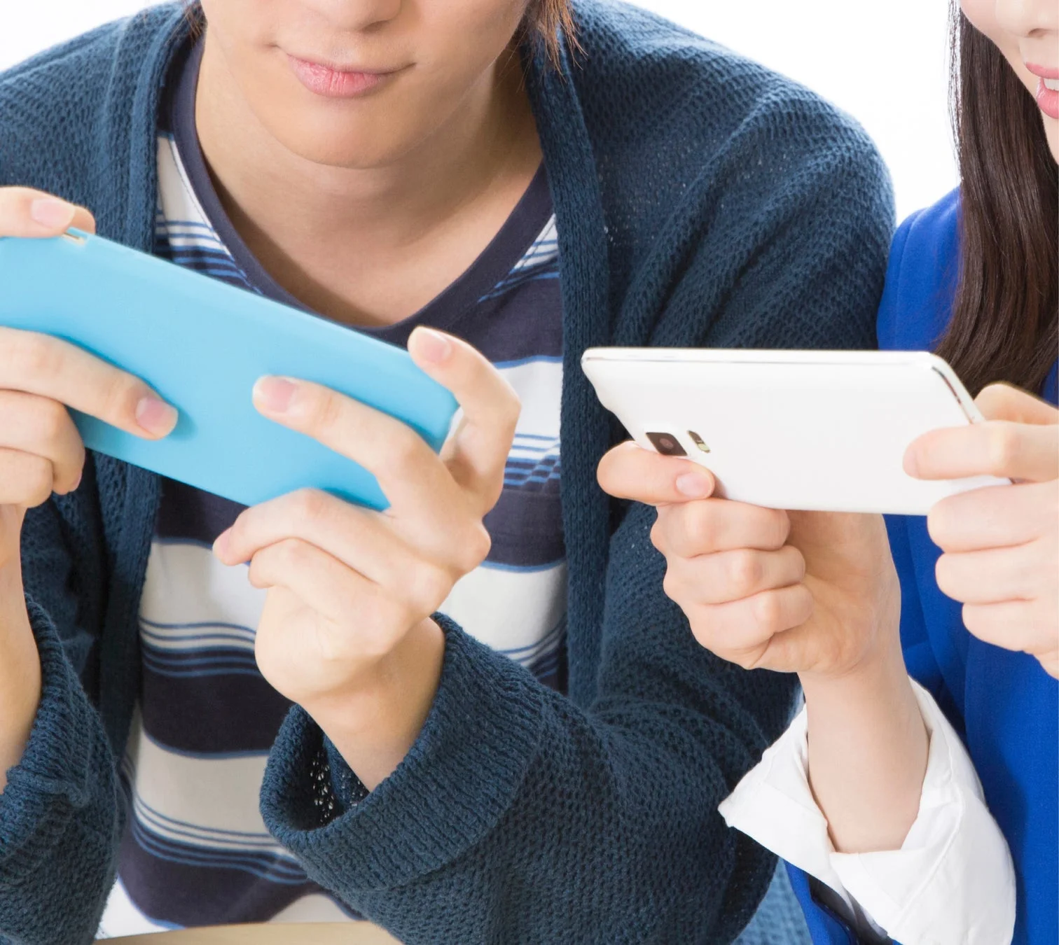 スマートフォンでゲームをする人々の手元