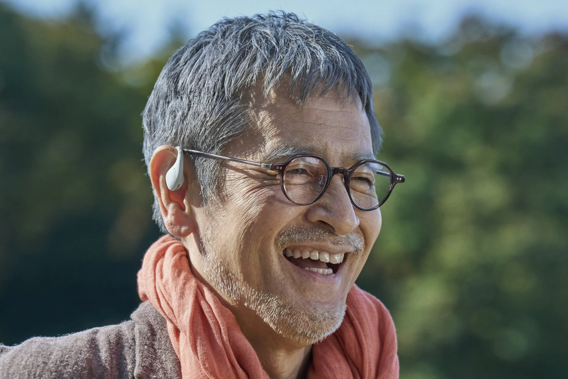 屋外で明るく笑う中年男性のポートレート