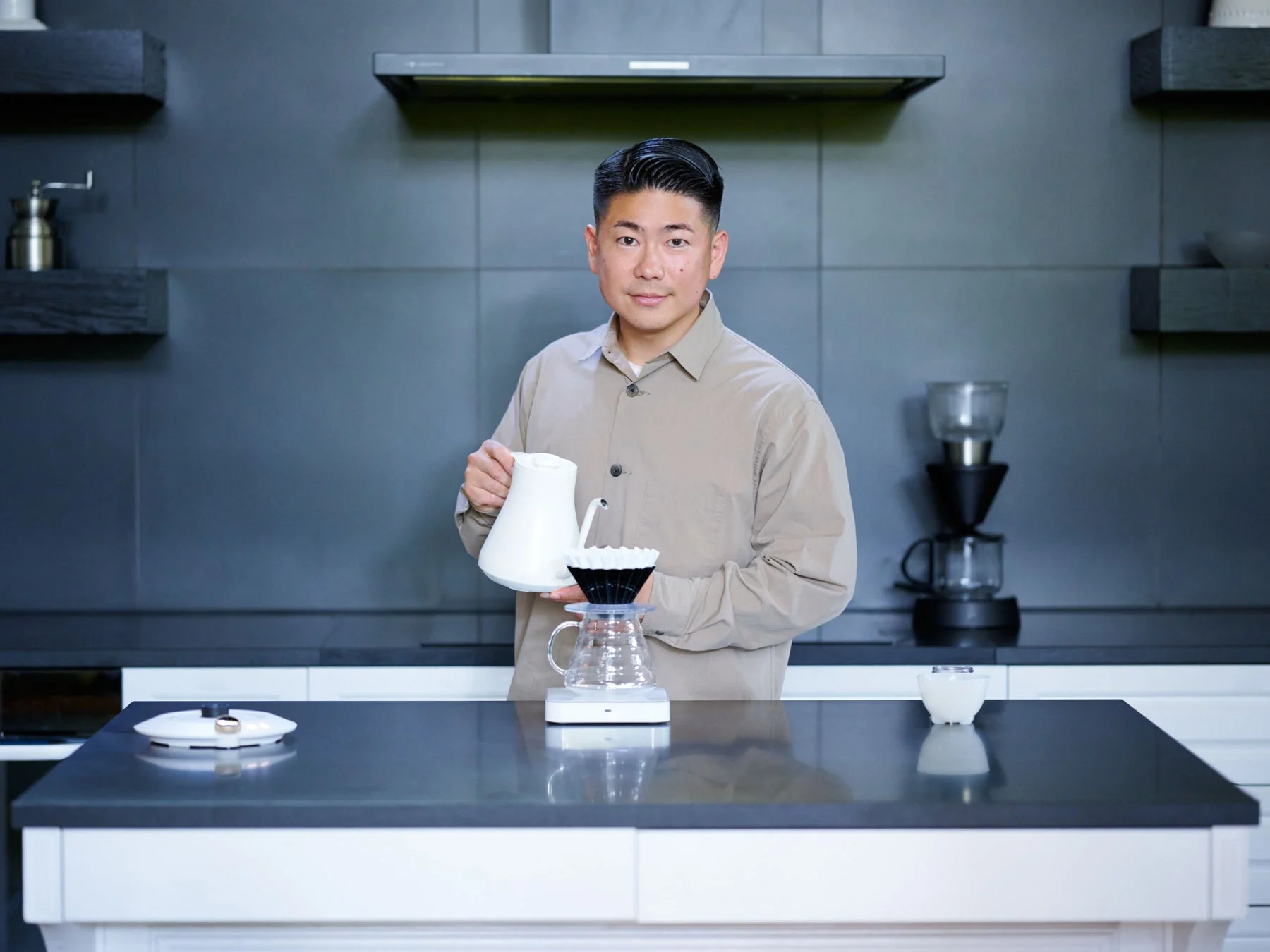 現代的なキッチンで、男性がハンドドリップコーヒーを淹れています