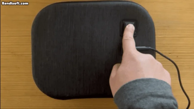 黒いデバイスの電源スイッチを操作する様子