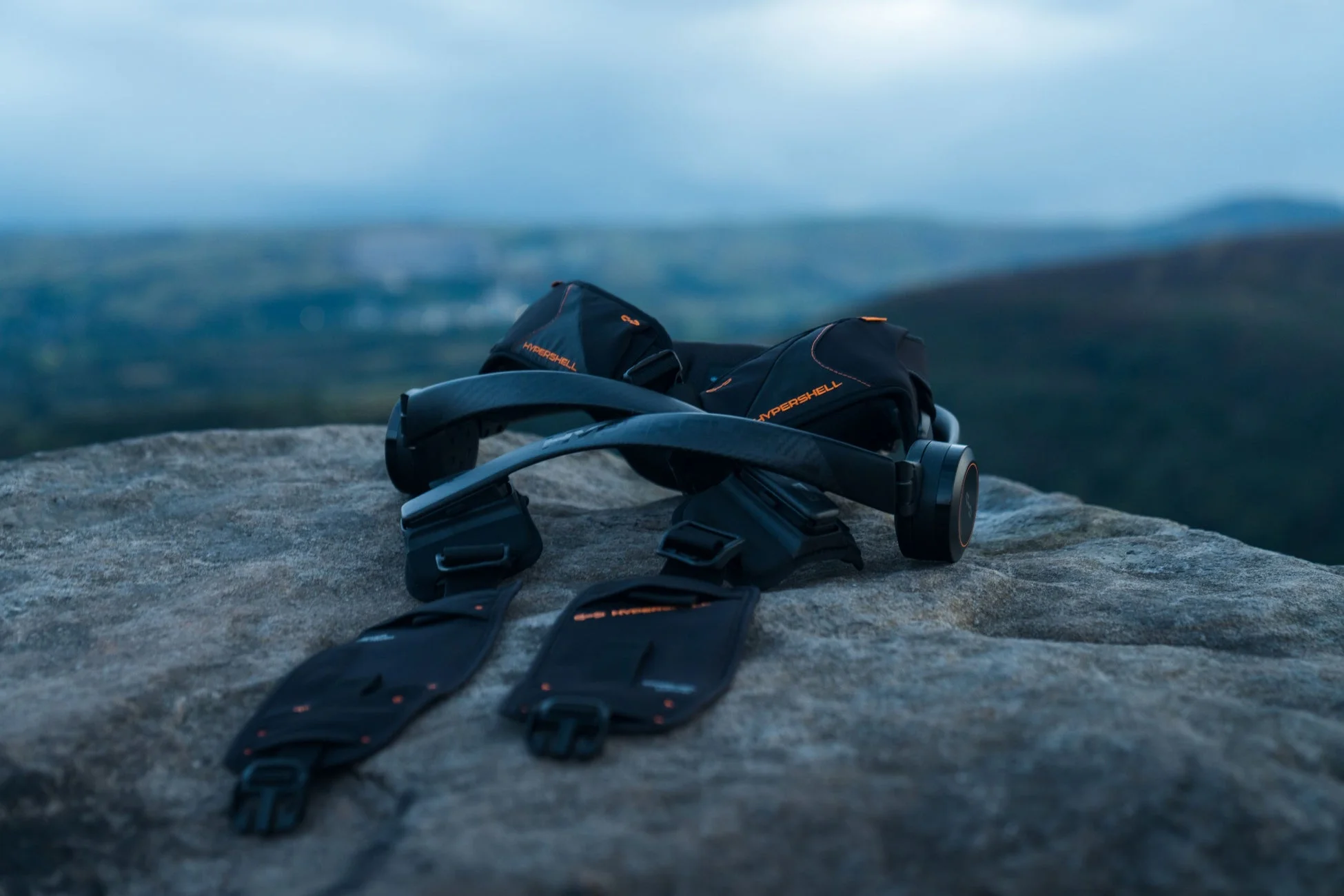 岩の上に置かれた黒いHYPERSHELLブランドのウェアラブルデバイスが写っています