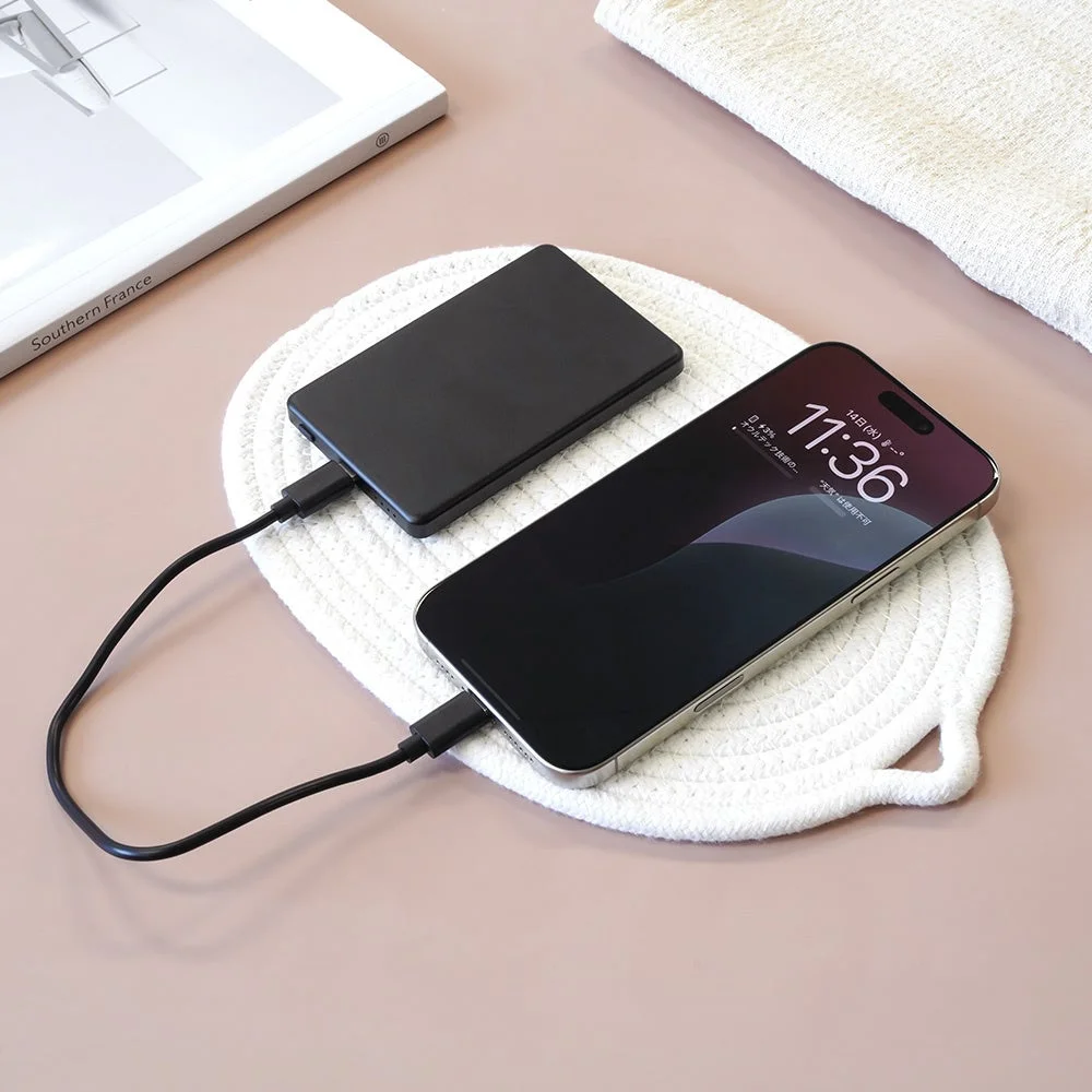 モバイルバッテリーからスマートフォンが有線充電されている様子