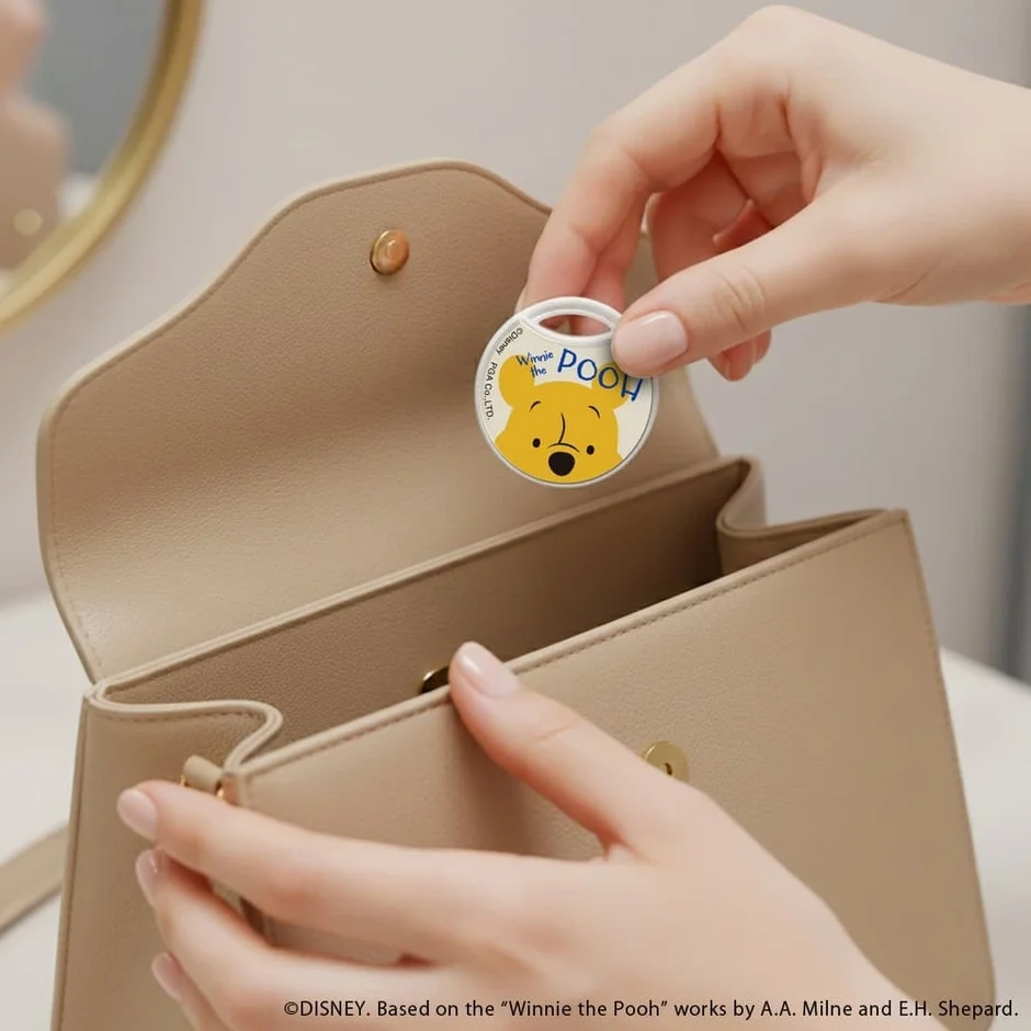 くまのプーさんの紛失防止タグをバッグに入れる様子