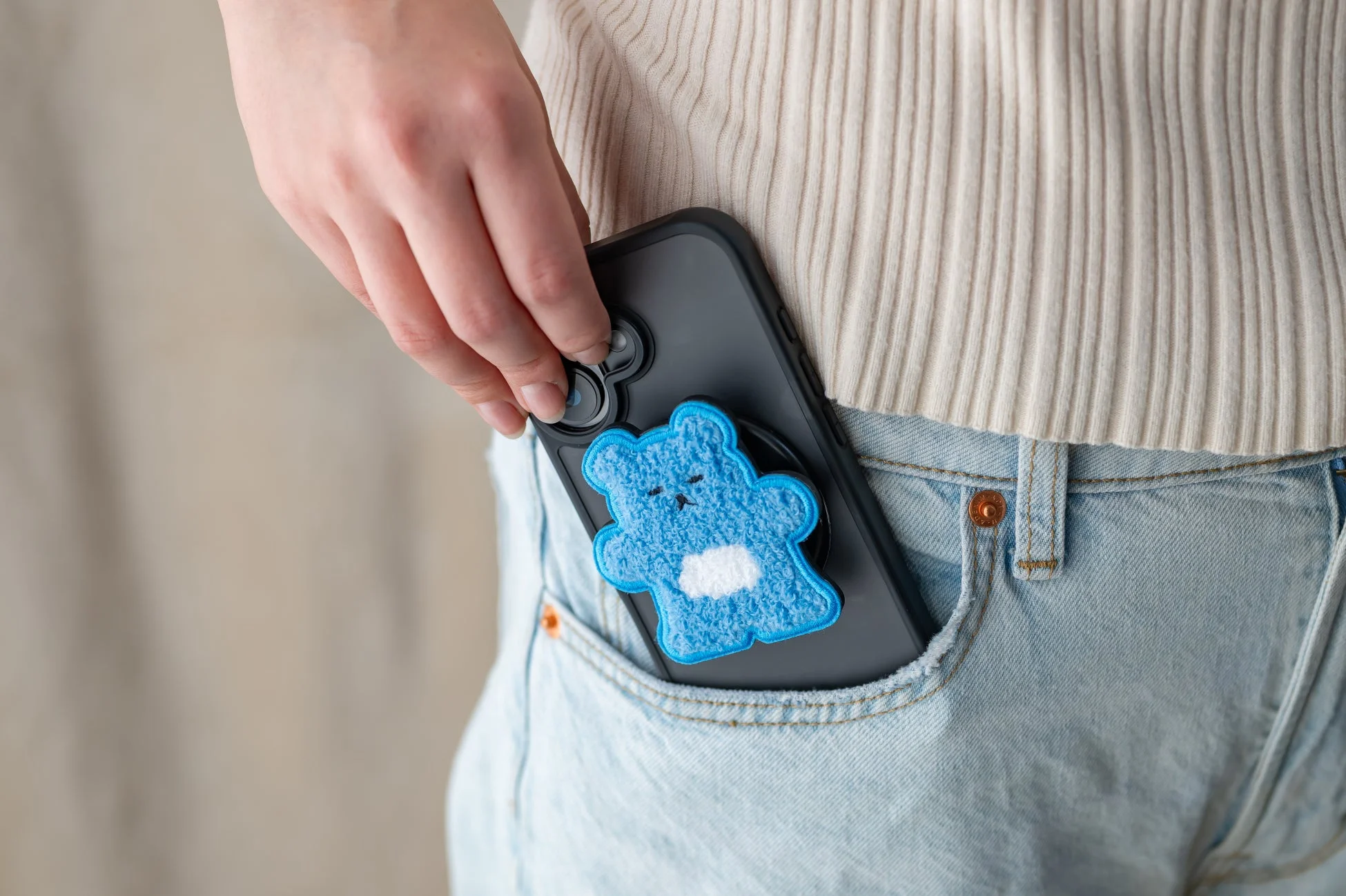 ジーンズのポケットにクマのグリップをしまう様子