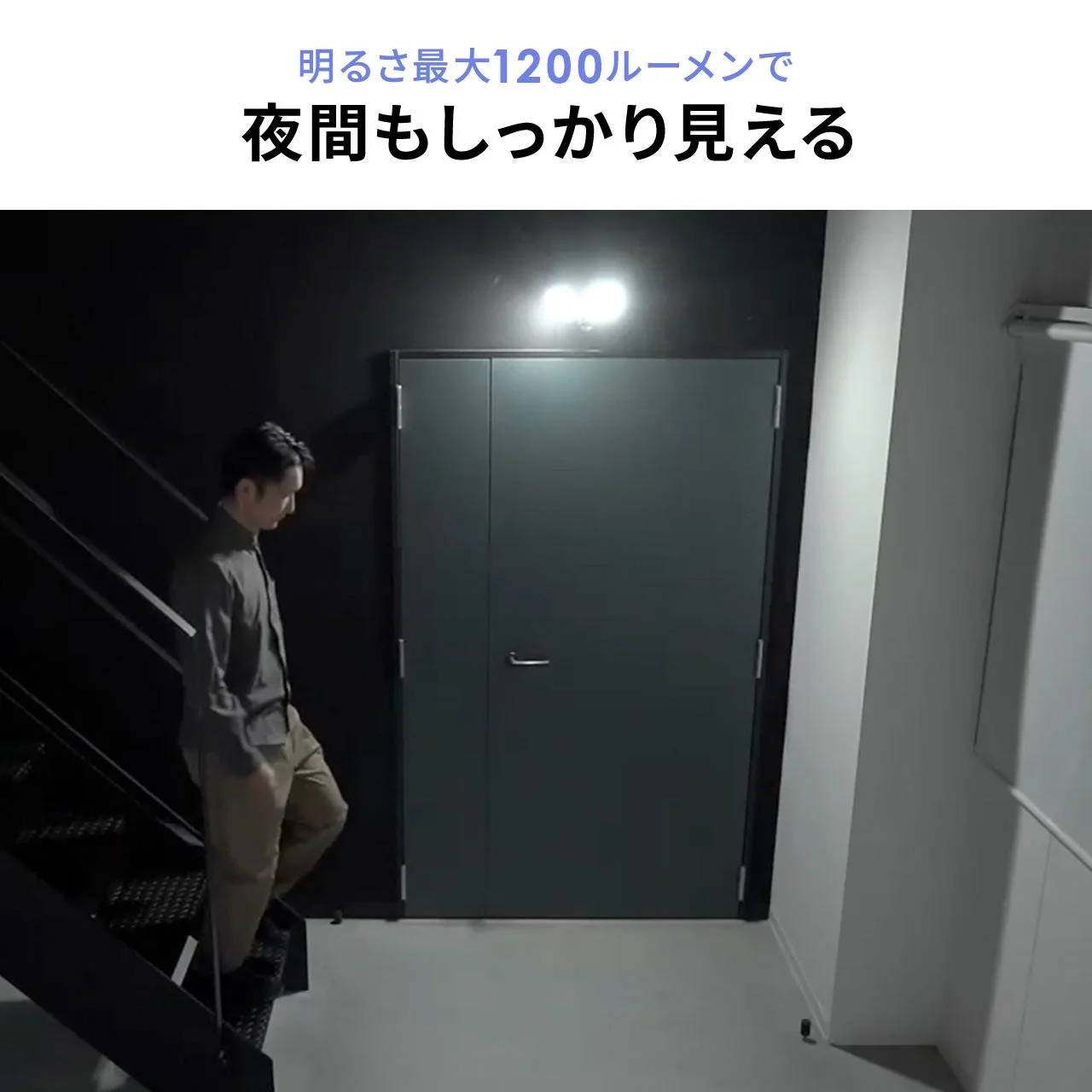 暗い室内で男性が階段を降りている様子を照らす照明