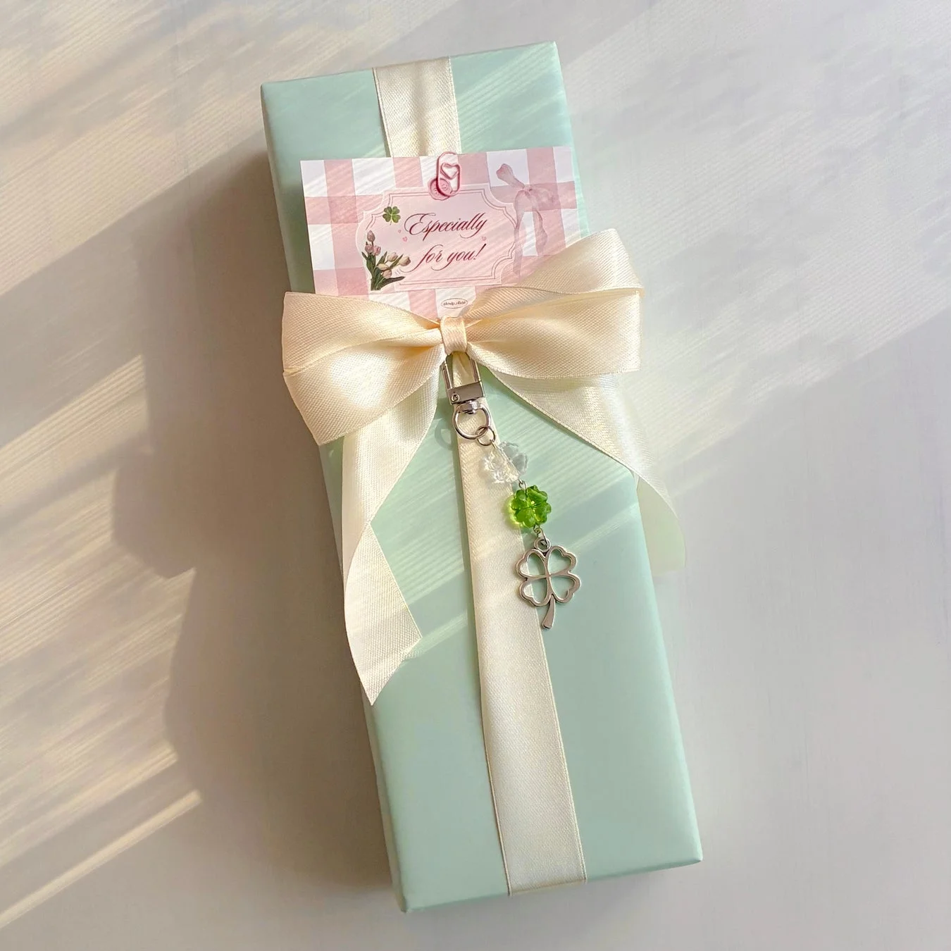 ミントグリーンのラッピングとクローバーチャームのギフト