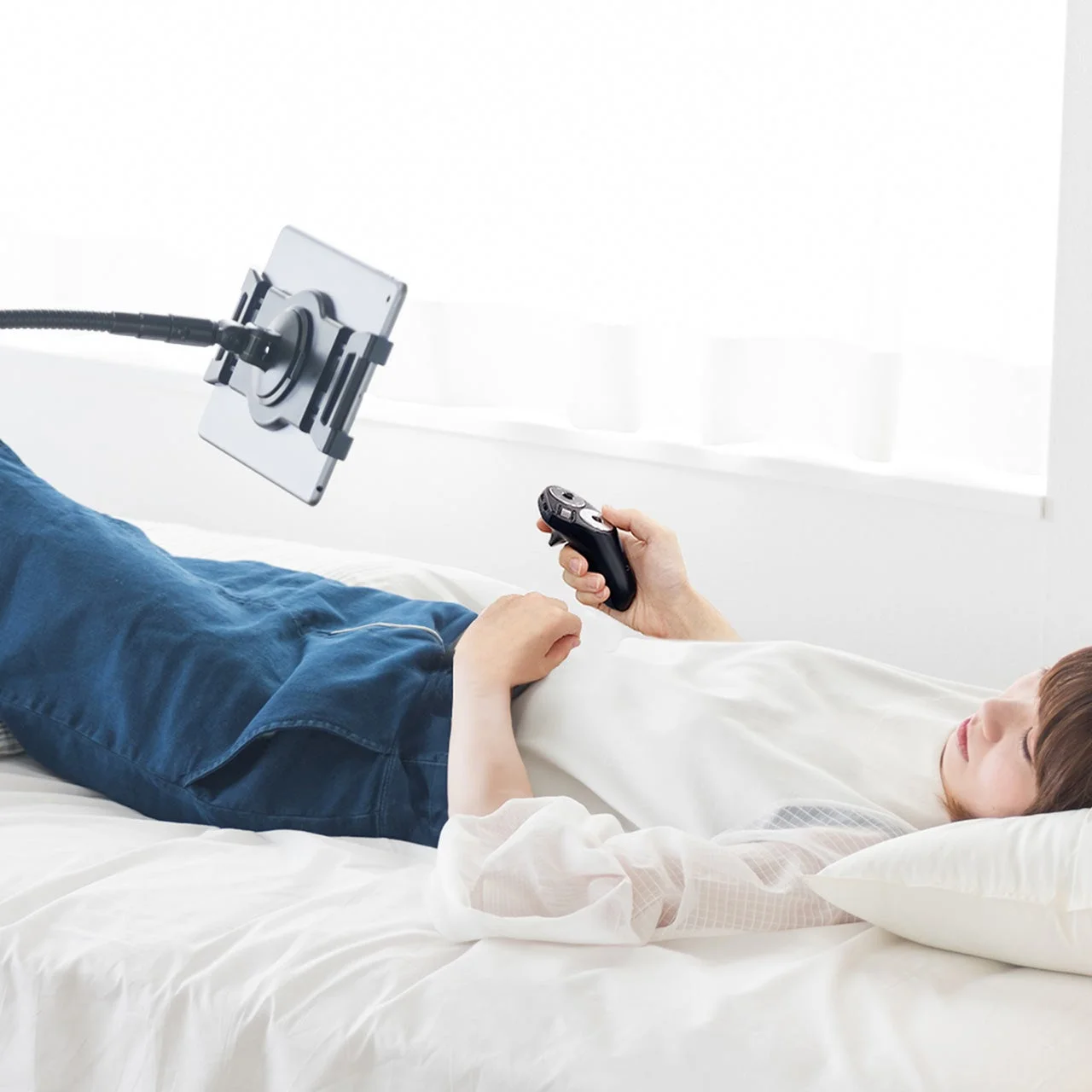 ベッドでタブレットを操作する様子