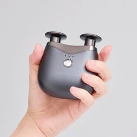 人の手がダークグレーの小型マッサージ器を持っている画像