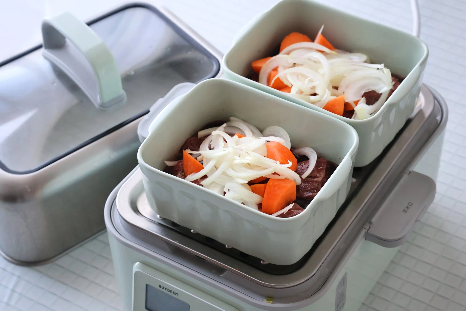 蒸し器に肉と野菜をセットする様子
