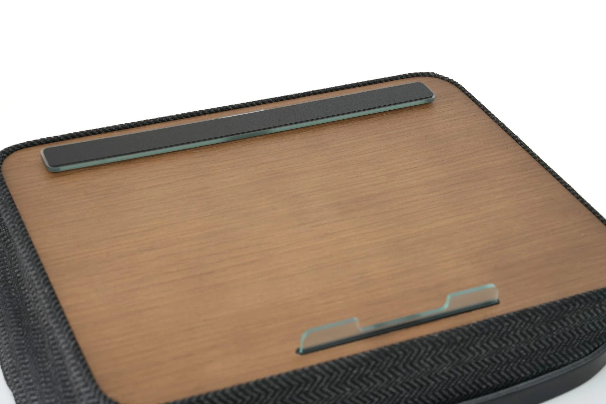 木目調の天板とクッション性のある底面を持つラップデスクです。ノートパソコンやタブレットを快適に使用するためのデザインで、上部と下部にはデバイスの滑り落ちを防ぐストッパーが付いています。