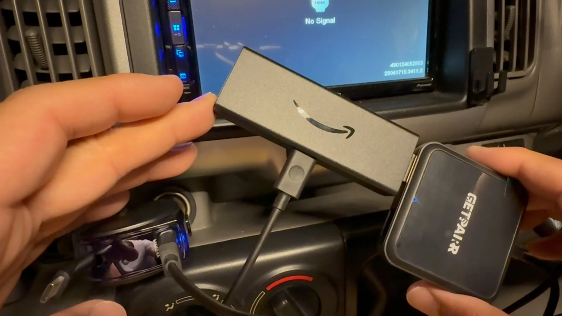 車内でAmazon Fire TV StickとGETPAIRデバイスを車のディスプレイに接続している様子です。
