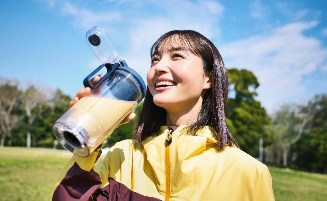 公園でドリンクを飲む女性