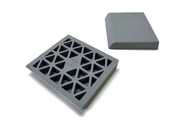 白い背景に、三角形の穴が開いた四角いグレーの格子状の物体と、シンプルな長方形のグレーのブロックが写っています