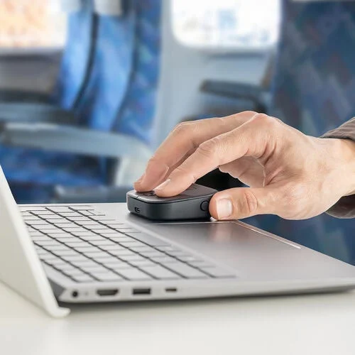 移動中にノートパソコンとモバイルマウスを使用する人