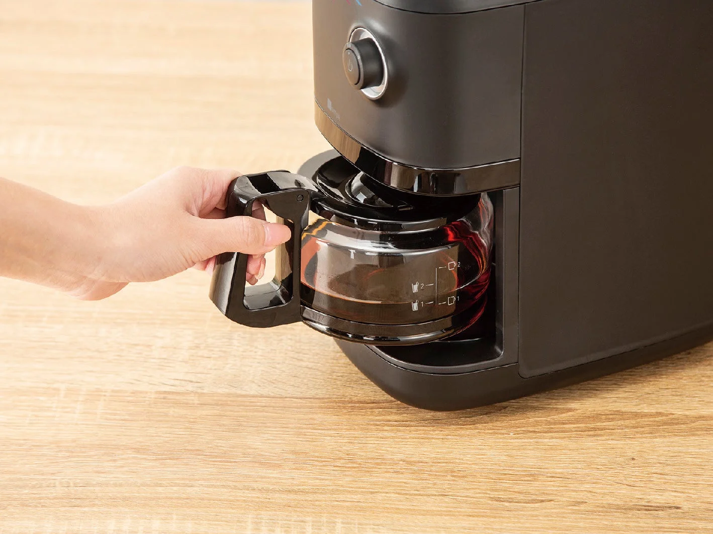 コーヒーメーカーからカラフェを取り出す様子