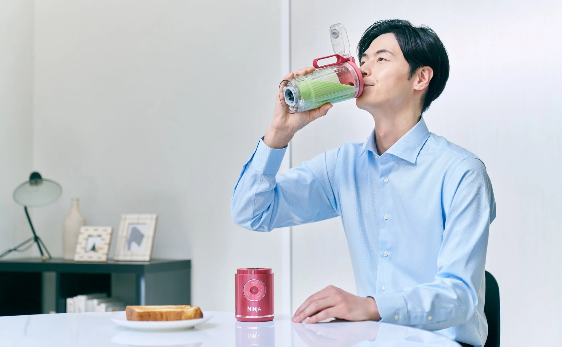 自宅でスムージーを飲む男性