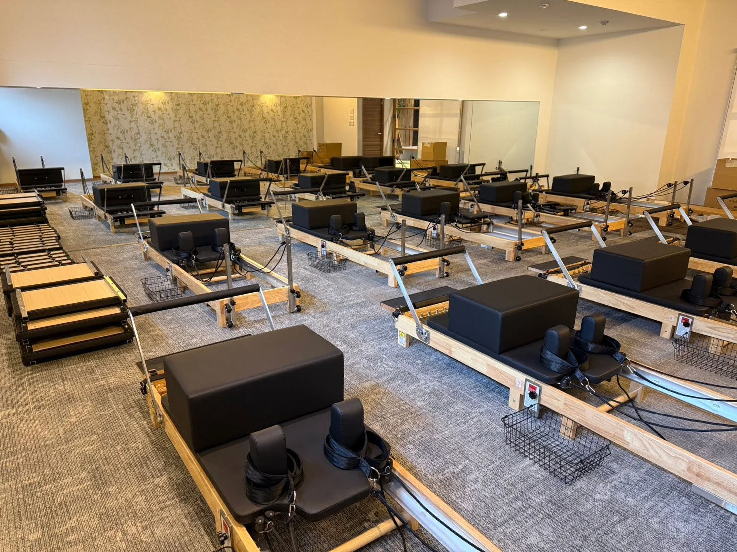 多くのピラティスリフォーマーマシンが並べられた広々としたスタジオ