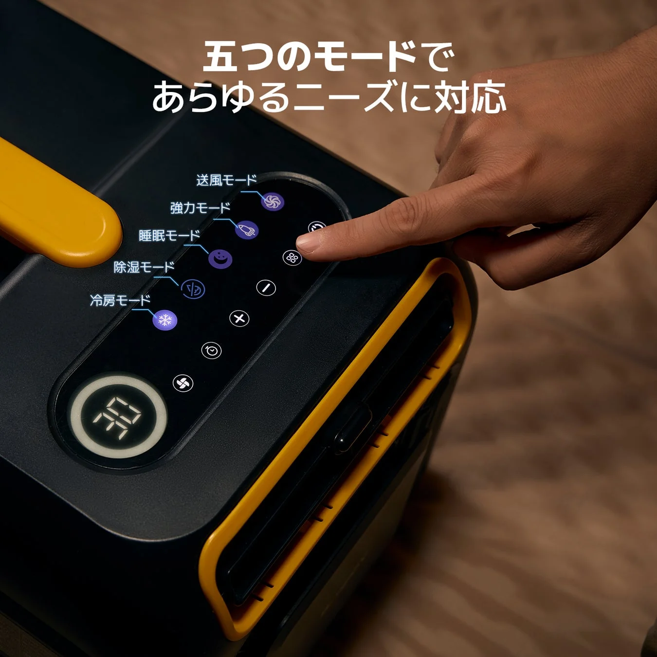 黒と黄色のポータブルエアコンの操作パネルを指で操作している様子。送風、強力、睡眠、除湿、冷房の5つのモードが表示され、あらゆるニーズに対応する多機能性をアピールしています。