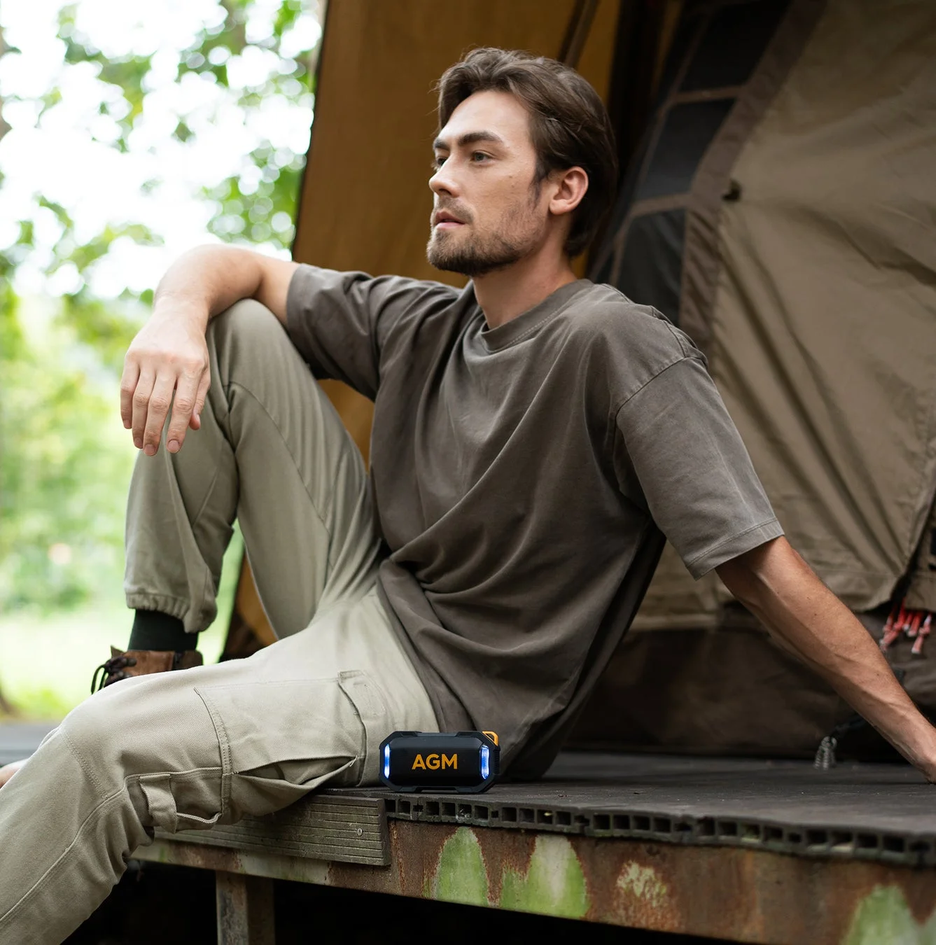 キャンプでポータブルスピーカーを使用する男性