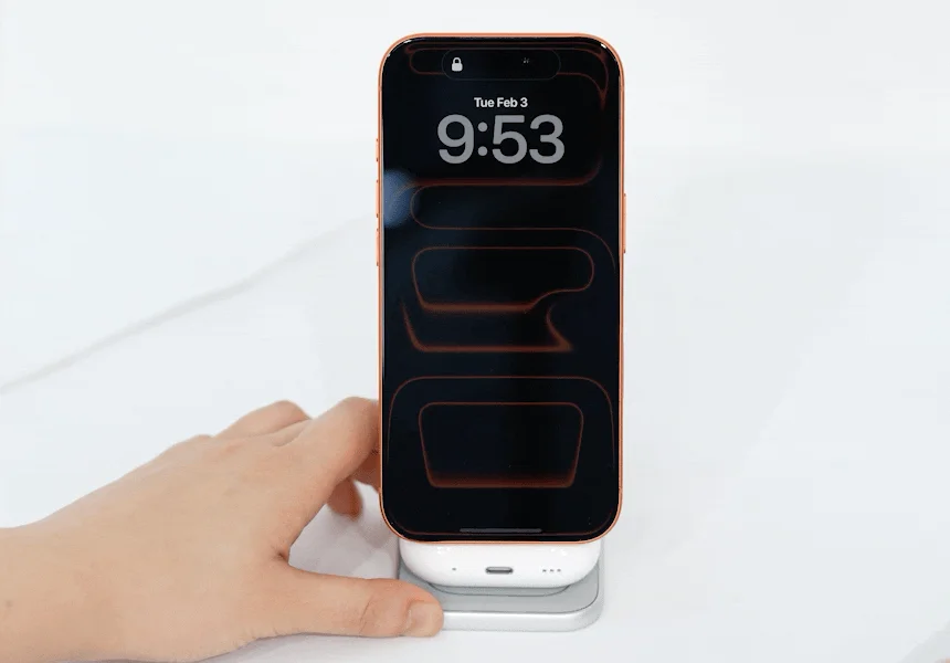 ローズゴールドのスマートフォンがワイヤレス充電器に置かれたAirPods Proのケースの上で充電されており、画面には「Tue Feb 3 9:53」と表示されています。