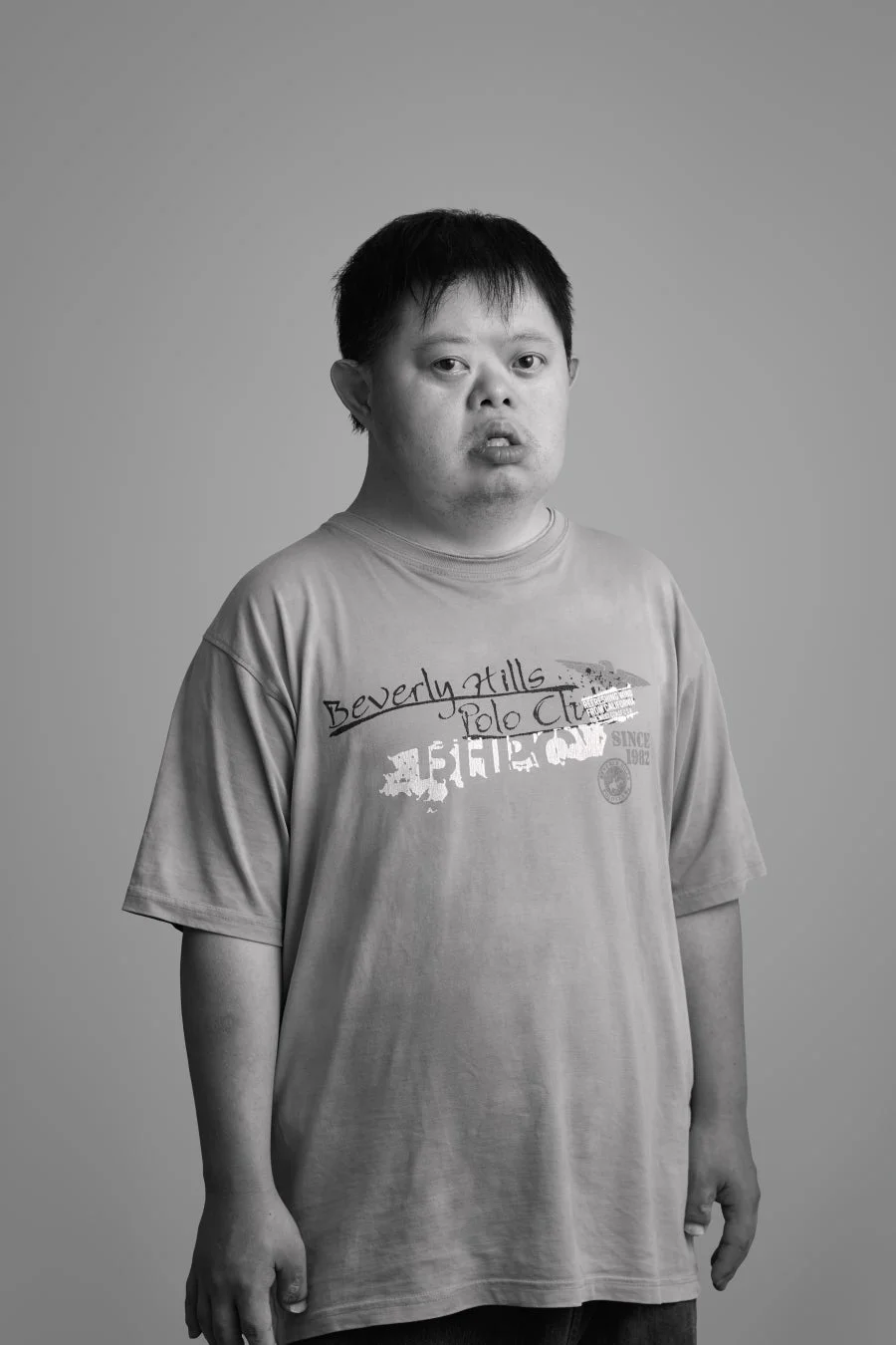 モノクロで撮影された、ダウン症の男性のポートレート。