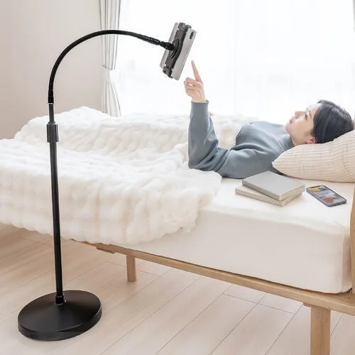 女性がベッドで寝ながらタブレットを使用