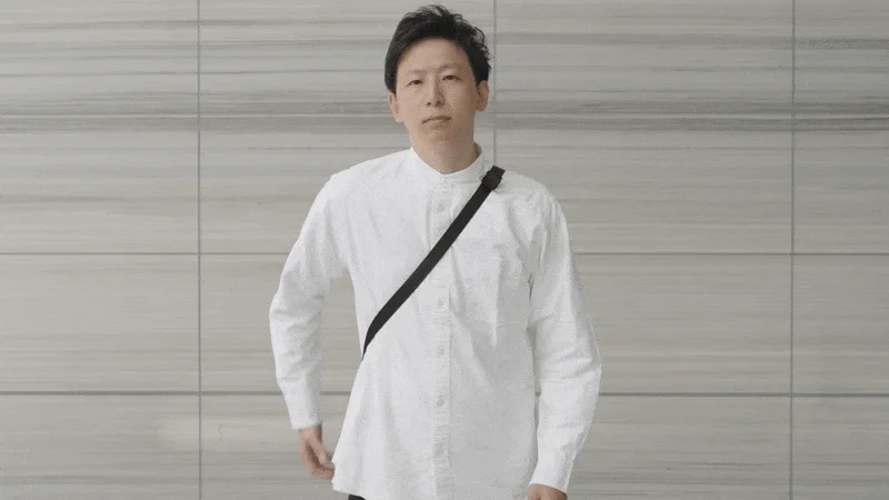 白いシャツを着た男性が黒い斜めがけバッグを身につけている様子