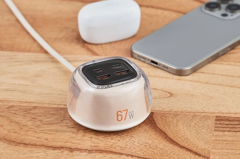 67W GaN対応の多ポートUSB充電器が置かれ、スマートフォンとワイヤレスイヤホンケースが周りに配置されている様子