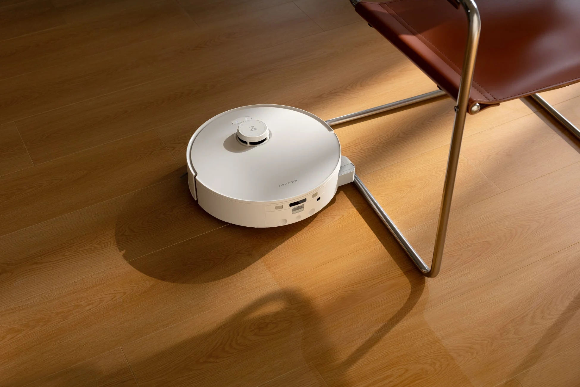 木目のフローリングで椅子近くを掃除するロボット掃除機