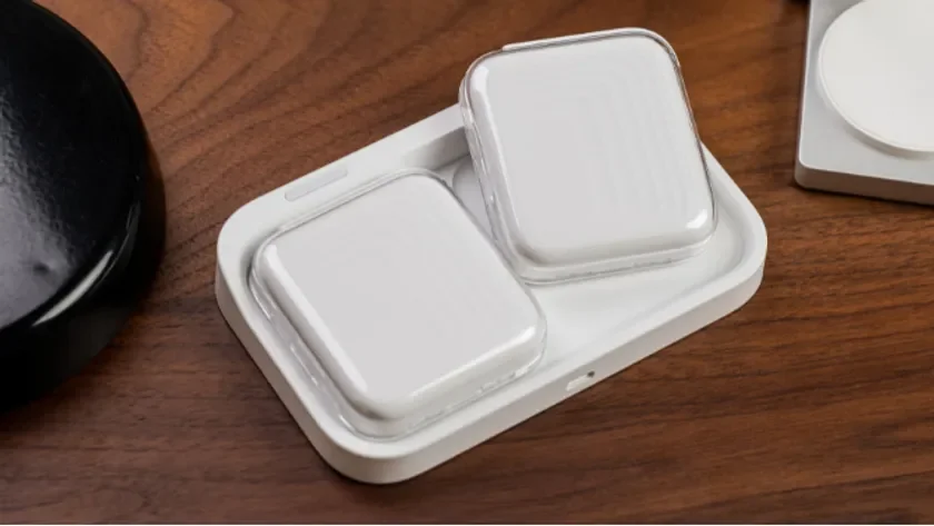 スマートウォッチのような白いデバイスが2つ置かれたワイヤレス充電器