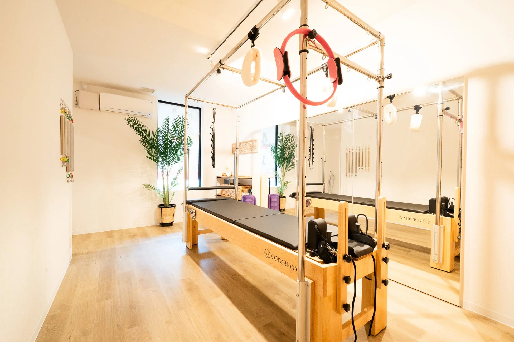 明るく清潔感のあるピラティススタジオの様子。最新のリフォーマーが複数設置されており、運動やリハビリテーションに適したモダンな空間です。
