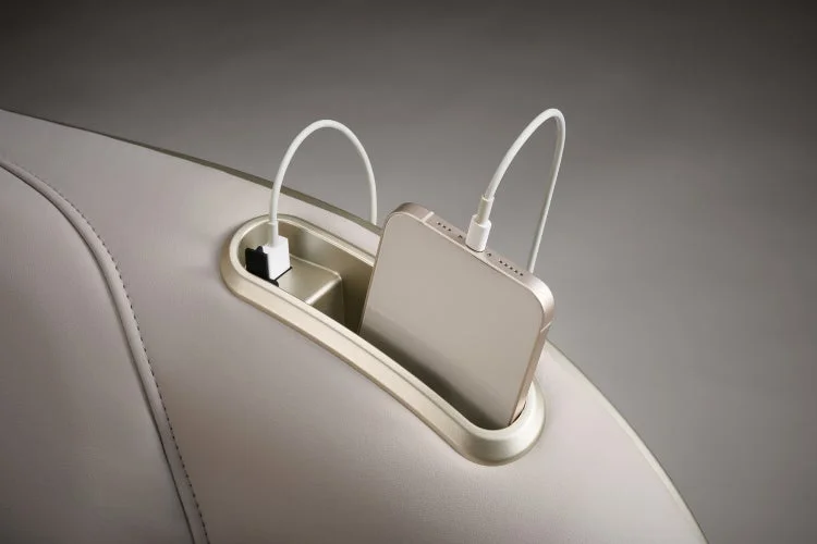 座席や家具の一部に組み込まれた収納スペースでスマートフォンが充電されている様子