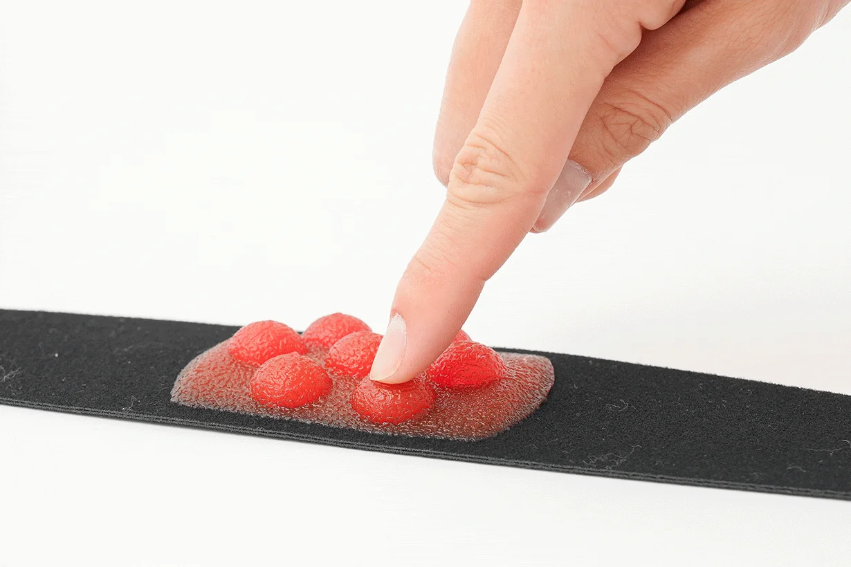 指、押す、赤い、突起、黒いバンド、健康器具、医療機器、ツボ押し、マッサージ、プレッシャー、テクスチャ、白背景