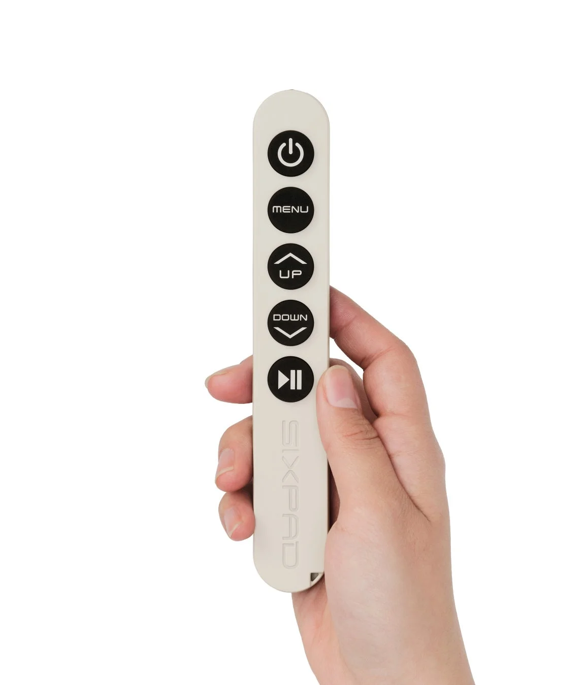 白いスリムなリモコンを片手で持っている画像です。電源、メニュー、上下、再生/一時停止のボタンがあり、本体側面には「SIXPAD」のロゴが見えます。
