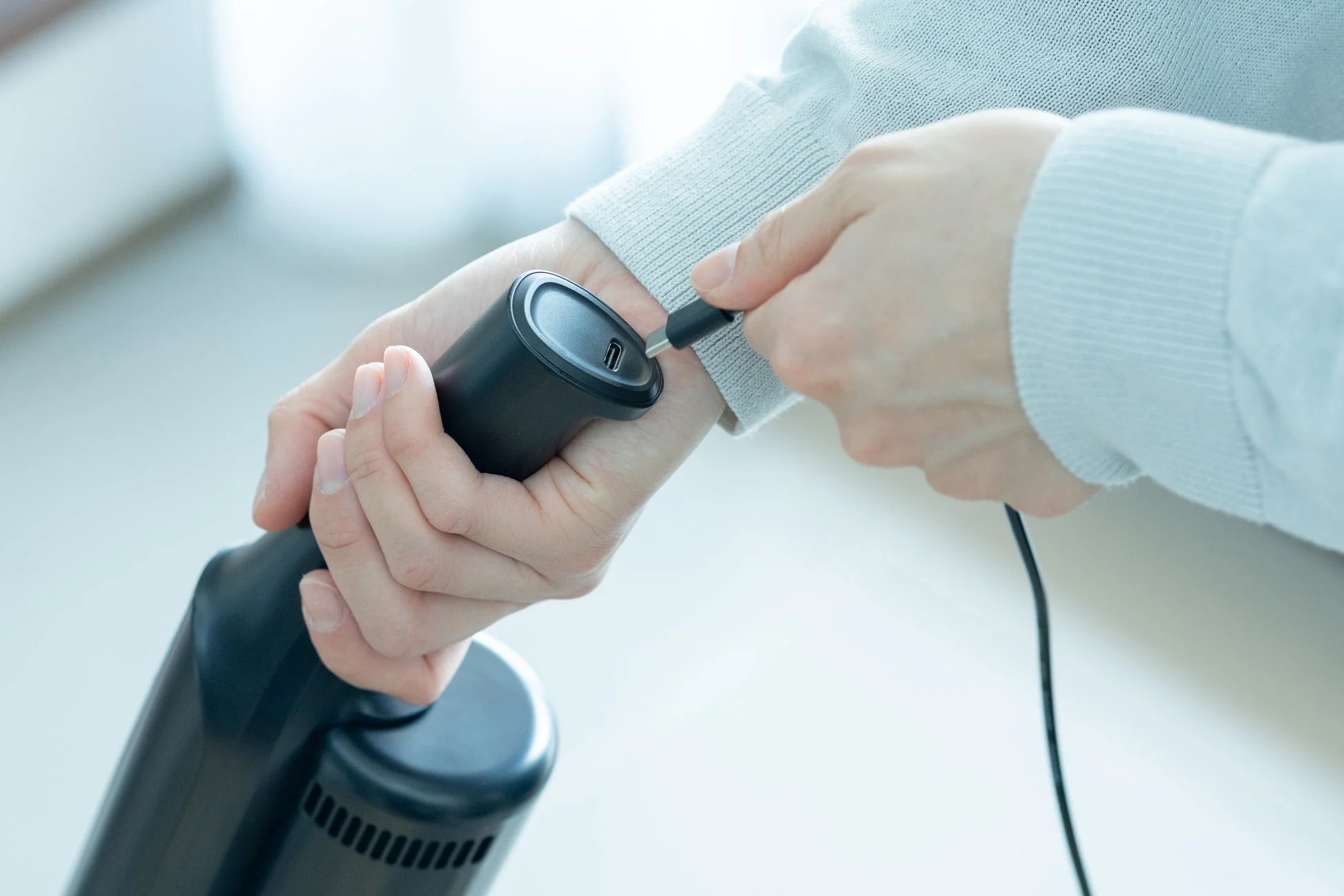 人物がUSB-Cケーブルを黒い電子機器に接続している様子