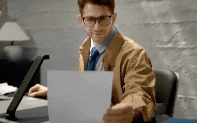 デスクで書類を見る男性