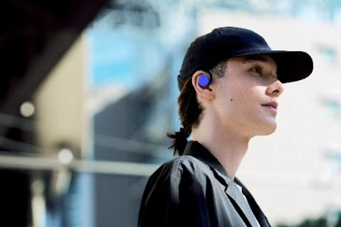 キャップをかぶりイヤホンを装着した男性の横顔