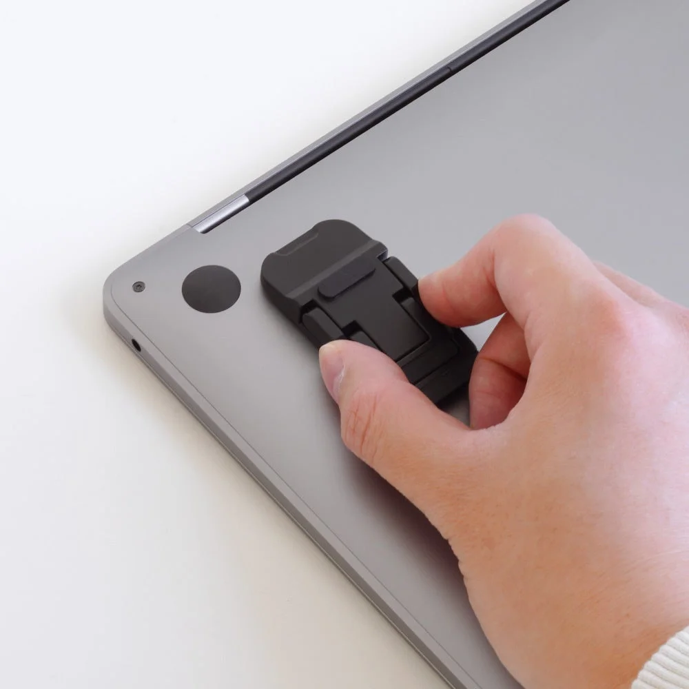 ノートPCに貼り付けようとしているミニスタンド