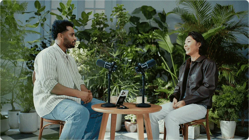 室内で男女が向かい合って座り、ポッドキャストの収録かインタビューを行っている様子